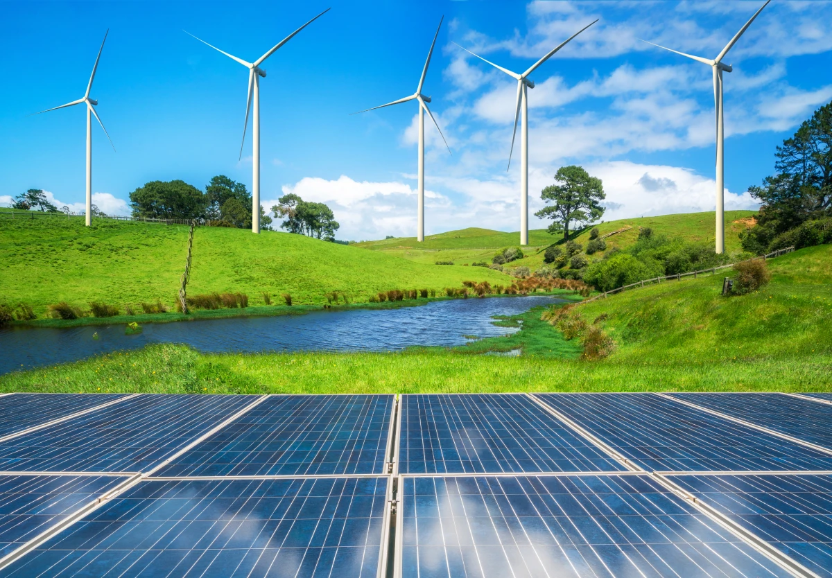 Wind turbines and solar panels on green hills
