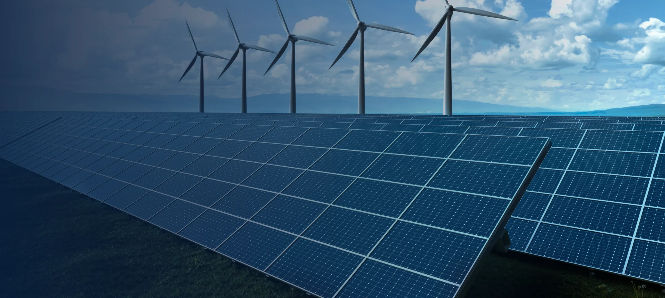 Rows of solar panels and wind turbines under a clear sky
